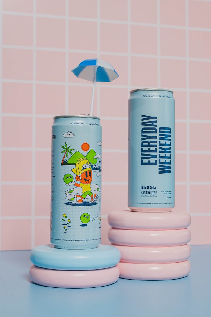 Two cans of iced tea with an umbrella on top